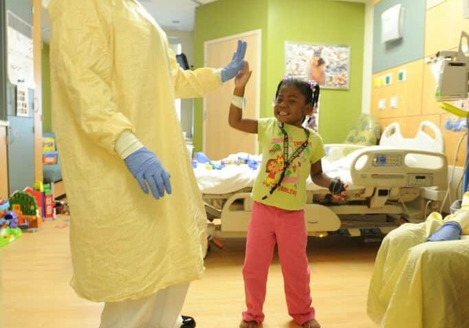 child in hospital giving a nurse a high five